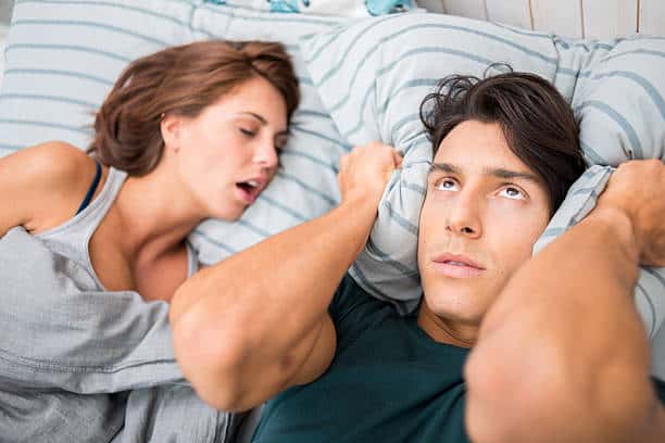 Man cannot sleep because his wife snores.